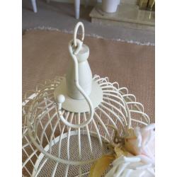 Cream ornamental bird cage with pale flowers attached. Used for a wedding.